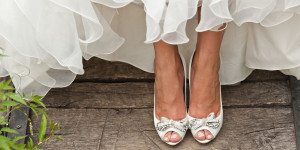 bride white open toe shoes decorated with bow and strass on wood boards