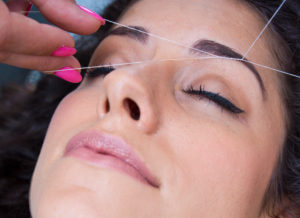 woman having her eyebrows threaded
